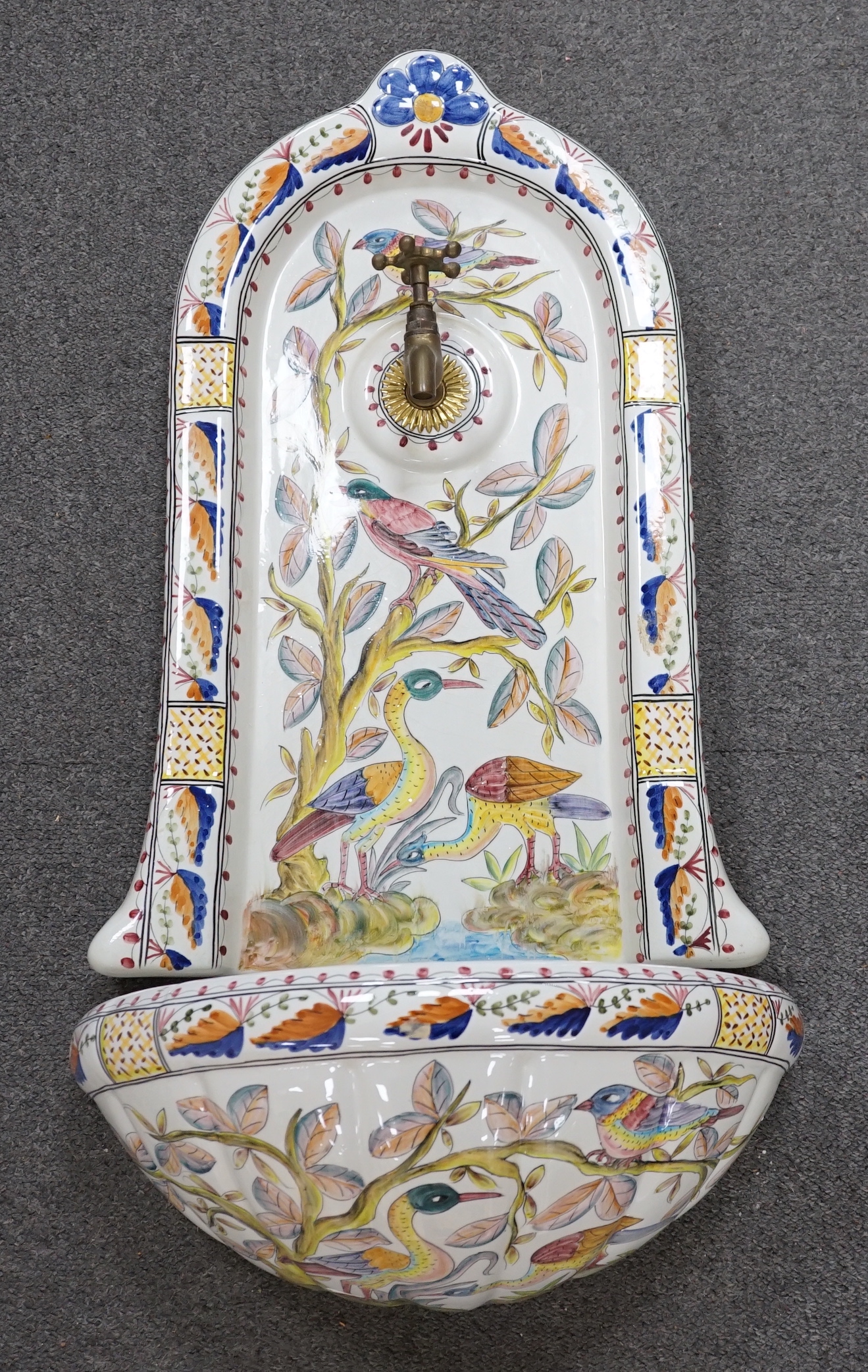 A Portuguese pottery font and basin, hand painted with birds and flowers, 66cm high